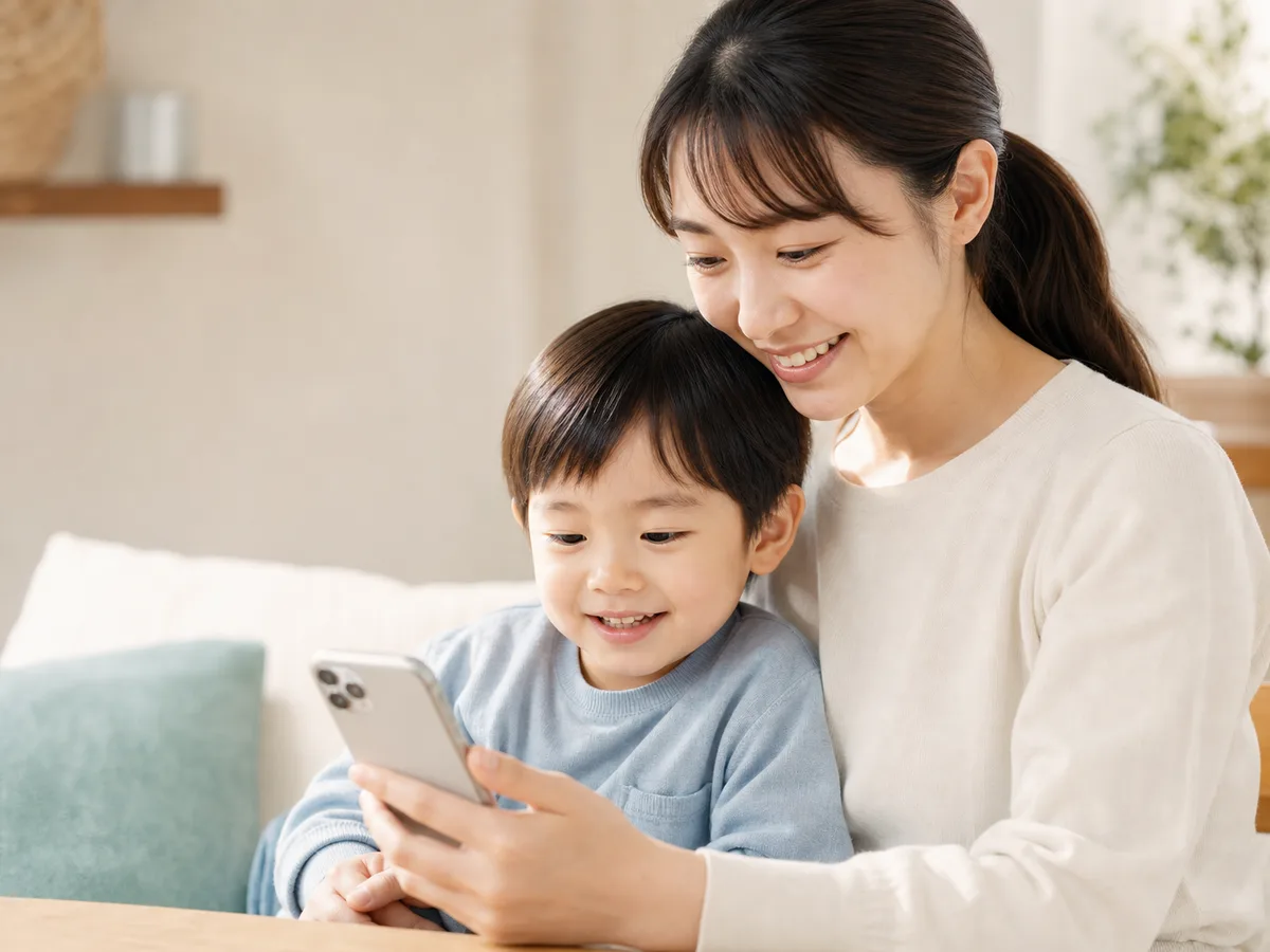 スマホでお知らせを確認する親子の写真